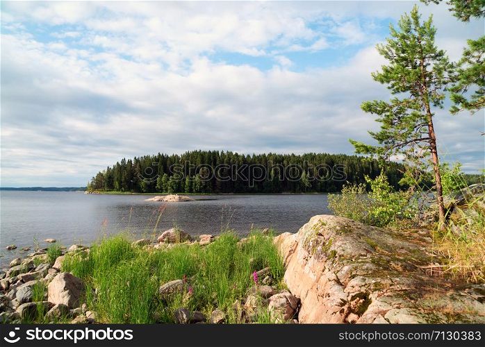 Picturesque stone shore of the island on the lake . Ladoga Skerries, Karelia.. On the shore of lake Ladoga with Islands in the distance .