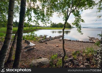 Picturesque stone shore of the island on the lake . Ladoga Skerries, Karelia.. Bench on the shore of lake Ladoga with Islands in the distance .