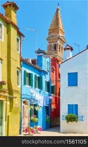Picturesque street and leaning old bell tower in Burano in Venice, Italy - Italian cityscape