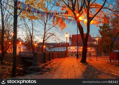 Picturesque Street at night, Vilnius, Lithuania. Picturesque Street and autumn park during evening blue hour in Old Town of Vilnius, Lithuania, Baltic states. Saint Anne church on the background.