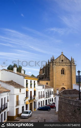Picturesque street in the medieval old town of Ronda leading to the Church of the Holy Spirit, located in Spain, Andalusia region.