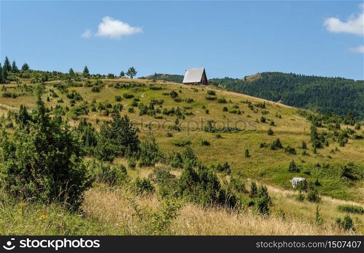 Picturesque summer mountain landscape of Durmitor National Park, Montenegro, Europe, Balkans Dinaric Alps, UNESCO World Heritage. Small wood hut on hill top.