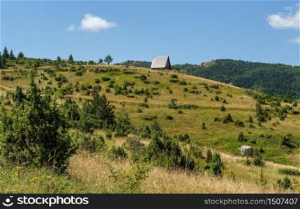 Picturesque summer mountain landscape of Durmitor National Park, Montenegro, Europe, Balkans Dinaric Alps, UNESCO World Heritage. Small wood hut on hill top.
