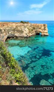 Picturesque sunshiny seascape with cliffs, rocky arch and stacks (faraglioni), at Torre Sant Andrea, Salento sea coast, Puglia, Italy