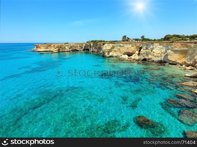 Picturesque sunshiny seascape with cliffs, rocky arch and stacks (faraglioni), at Torre Sant Andrea, Salento sea coast, Puglia, Italy
