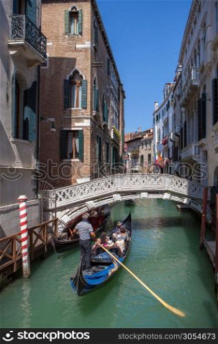 Picturesque view of Gondola on lateral narrow Canal, Venice, Italy. Classical picture of venetian canals with gondola across canal.. Venice canal scene in Italy
