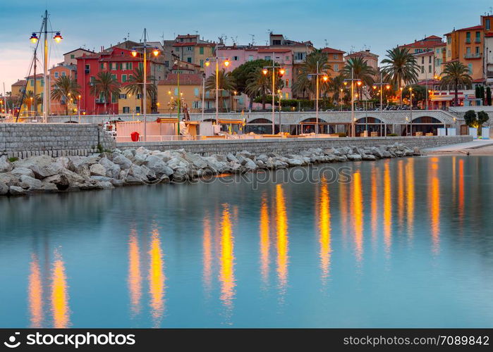 Picturesque view of the multicolored medieval houses in the historic part of the city. Menton. France. Cote d&rsquo;Azur.. Menton. Antique multi-colored facades of medieval houses on the shore of the bay.