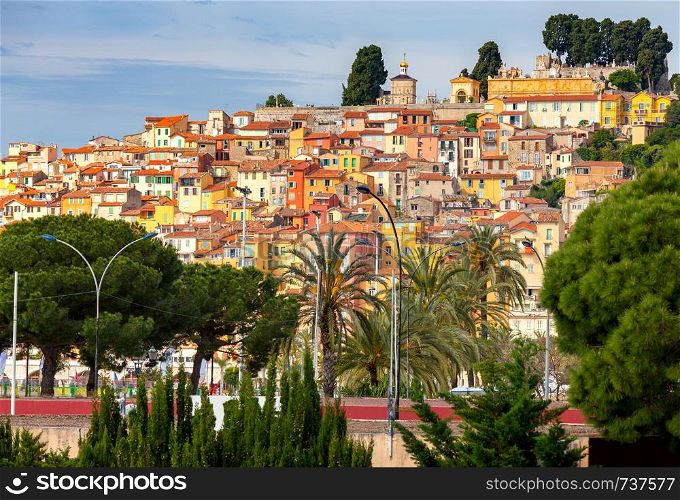 Picturesque view of the multicolored medieval houses in the historic part of the city. Menton. France. Cote d'Azur.. Menton. Antique multi-colored facades of medieval houses on the shore of the bay.