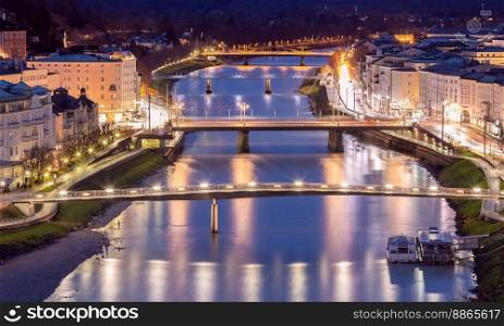 Picturesque view of the old city against the backdrop of bridges across the river at sunset. Salzburg. Austria.. Salzburg. Picturesque view of the old historical part of the city at sunset.