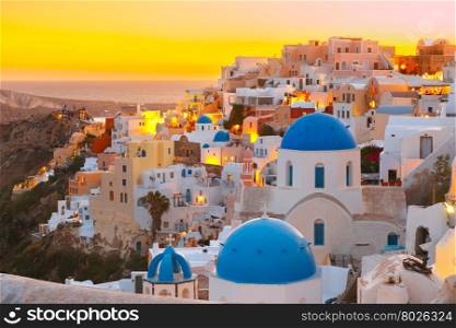 Picturesque view, Old Town of Oia or Ia on the island Santorini, white houses and church with blue domes at sunset, Greece