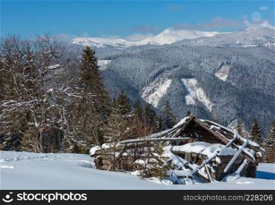 Picturesque winter mountain view from Skupova mountain slope, Ukraine. Old ruined wooden shed and view to Chornohora ridge and Pip Ivan mountain top with observatory building, Carpathian.