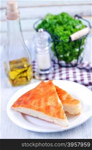 pie with cheese on plate and on a table