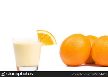 piece of a orange on a milkshake in front of oranges. piece of a orange on a orange milkshake in front of oranges on white background