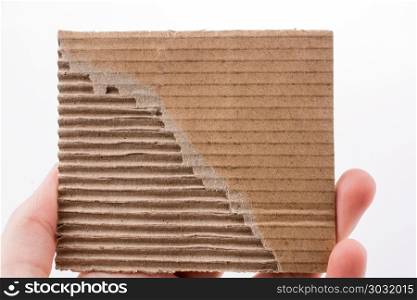 Piece of brown color cardboard in hand. Child holding a piece of brown color cardboard