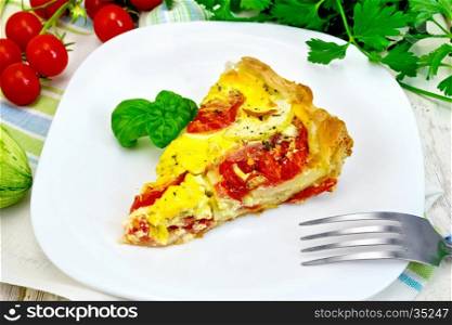 Piece of cake of zucchini with tomatoes and eggs, basil in a plate on a napkin, parsley on a wooden boards background