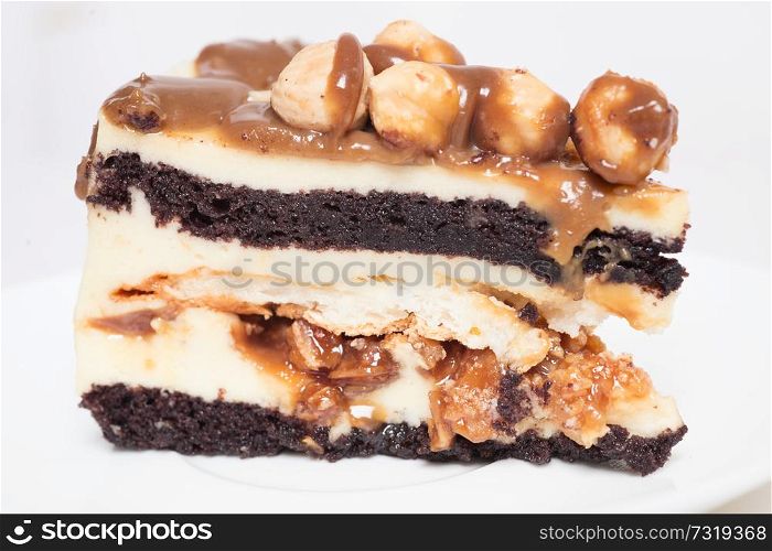 piece of cake with caramel and hazelnut at white background
