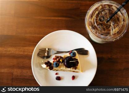 Piece of carrot fruit cake and ice coffee on coffee cafe, close up top view