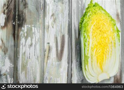 Piece of Chinese cabbage. On a wooden background.. Piece of Chinese cabbage.