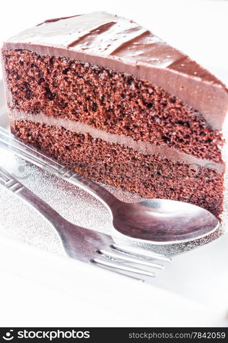 Piece of chocolate cake with spoon and fork