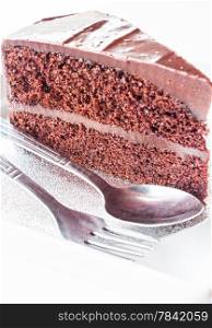 Piece of chocolate cake with spoon and fork