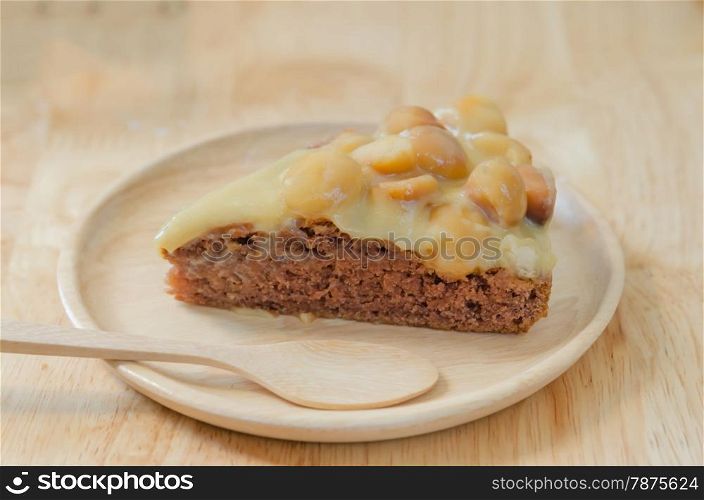 Piece of chocolate macadamia cake on wooden plate. chocolate macadamia cake