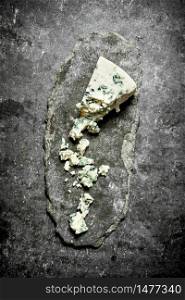 piece of French blue cheese .On the stone table.. piece of French blue cheese .