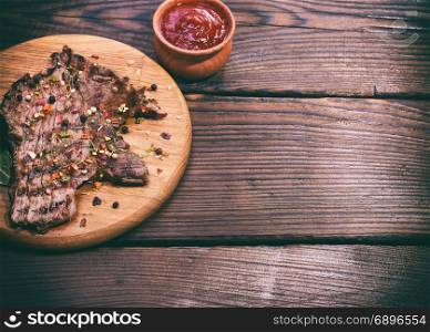 piece of fried veal with spices on a cutting board, empty space on the right