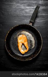 piece of grilled salmon in an old pan. On the black chalkboard.. piece of grilled salmon in an old pan.