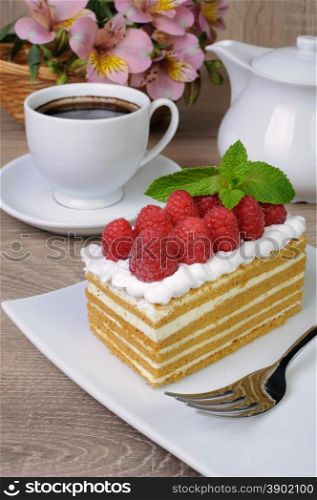 Piece of honey cake with whipped cream and raspberries