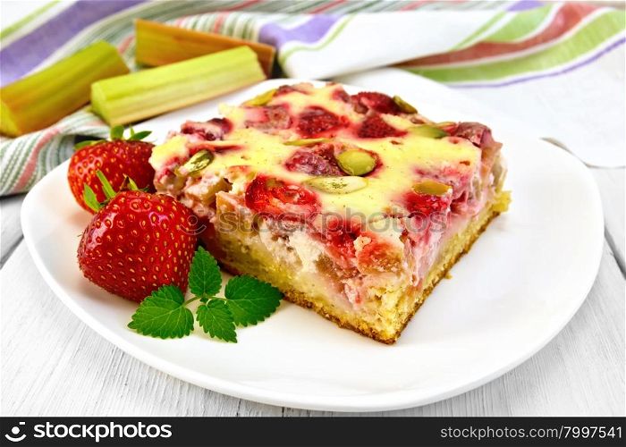 Piece of pie with strawberries, rhubarb and cream sauce, fork, strawberry, mint in white plate, a napkin on the background light wooden boards