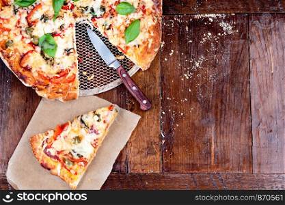 Piece of pizza on wooden table. Copy space on the right. View from above