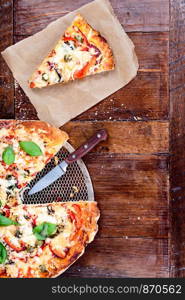 Piece of pizza on wooden table. Copy space on the right. View from above