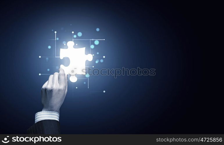 Piece of puzzle. Close up of businessman hand holding glowing jigsaw element