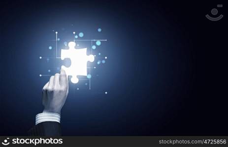 Piece of puzzle. Close up of businessman hand holding glowing jigsaw element