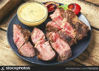Piece of roast beef with spices.Delicious beef steak and meat sauce.. Grilled beef steaks