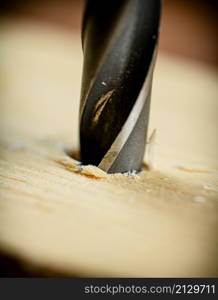 Piece of wood is drilled with shavings. On a wooden background. High quality photo. Piece of wood is drilled with shavings.