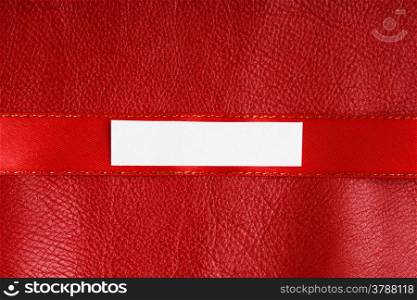 Piece scrap of white paper banner, blank copy space for text message on ribbon red leather background
