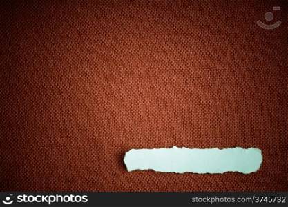 Piece scrap of white paper blank copy space on brown fabric textile material background