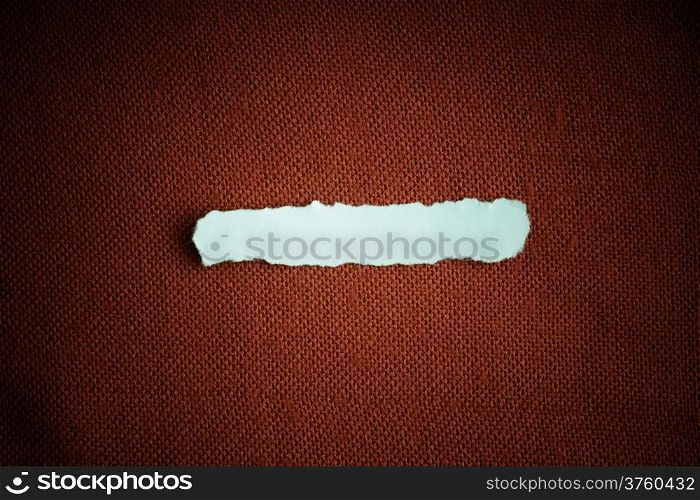 Piece scrap of white paper blank copy space on red fabric textile material background