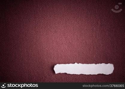 Piece scrap of white paper blank copy space on red fabric textile material background