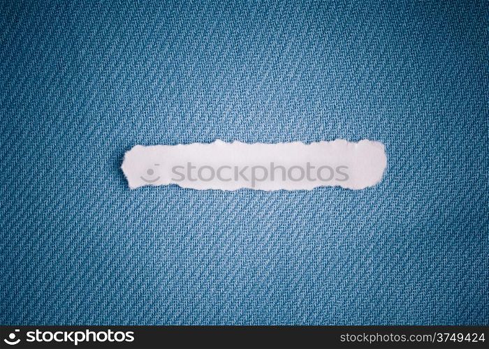 Piece scrap of white torn or ripped paper banner, blank copy space for text message on navy blue fabric textile material background
