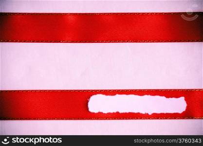 Piece scrap of white torn or ripped paper banner, blank copy space for text message red ribbon pink cloth background.