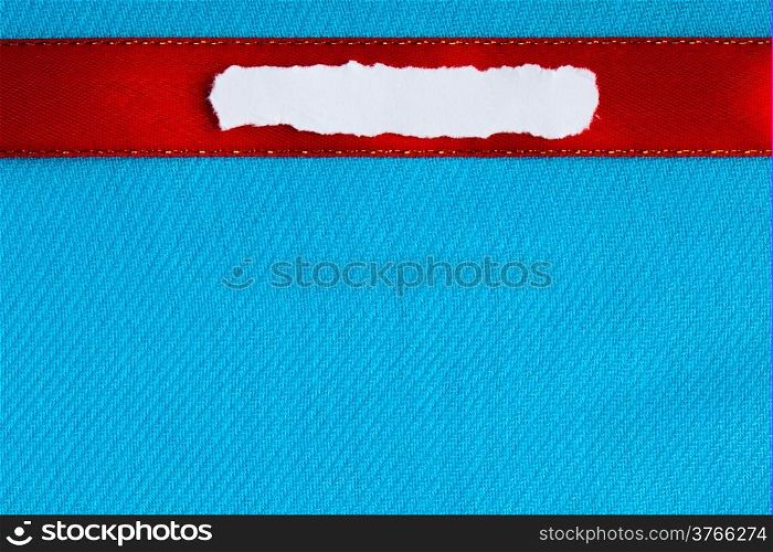Piece scrap of white torn or ripped paper banner, blank copy space for text message red ribbon on blue cloth background.