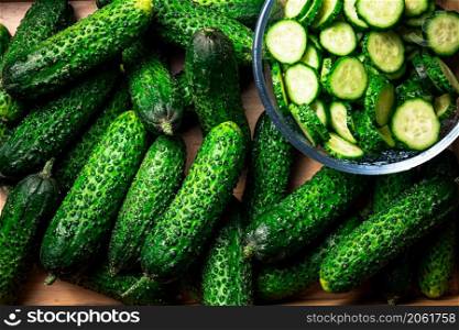 Pieces and whole ripe cucumbers. On a wooden background. High quality photo. Pieces and whole ripe cucumbers.
