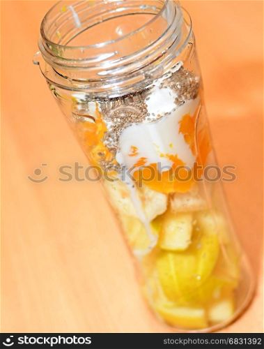 Pieces of a Raw Fruit with Plain Yogurt and Chia Seeds in a Plastic Bottle Before Making a Smoothie Cocktail.