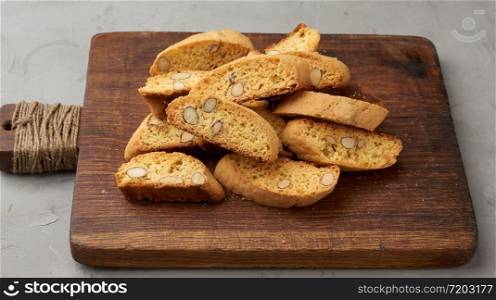 pieces of baked italian christmas biscotti cookies on a brown wooden board, close up