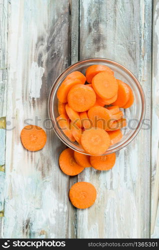 Pieces of carrots in a glass bowl. On wooden background. Pieces of carrots in a glass bowl.