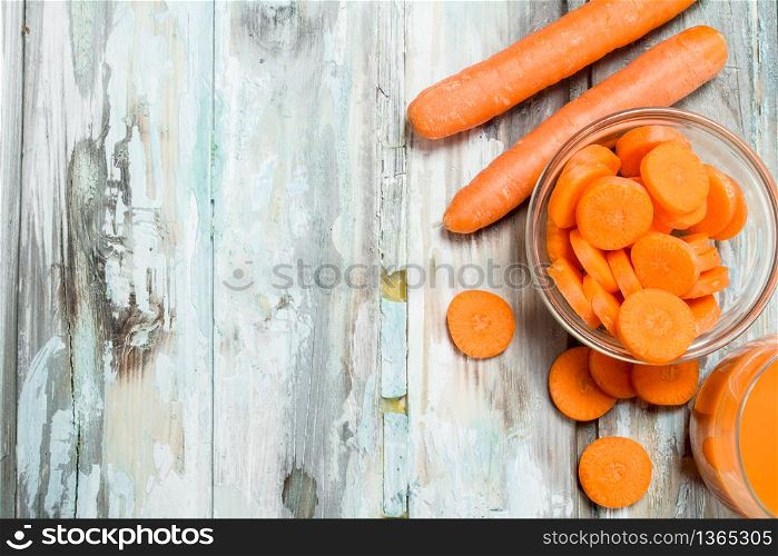 Pieces of carrots in a glass bowl. On wooden background. Pieces of carrots in a glass bowl.