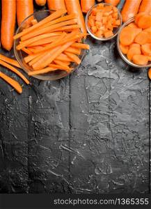 Pieces of carrots on a bowl. On black rustic background. Pieces of carrots on a bowl.