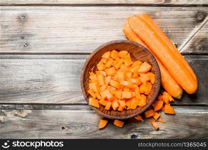 Pieces of carrots on a bowl. On wooden background. Pieces of carrots on a bowl.